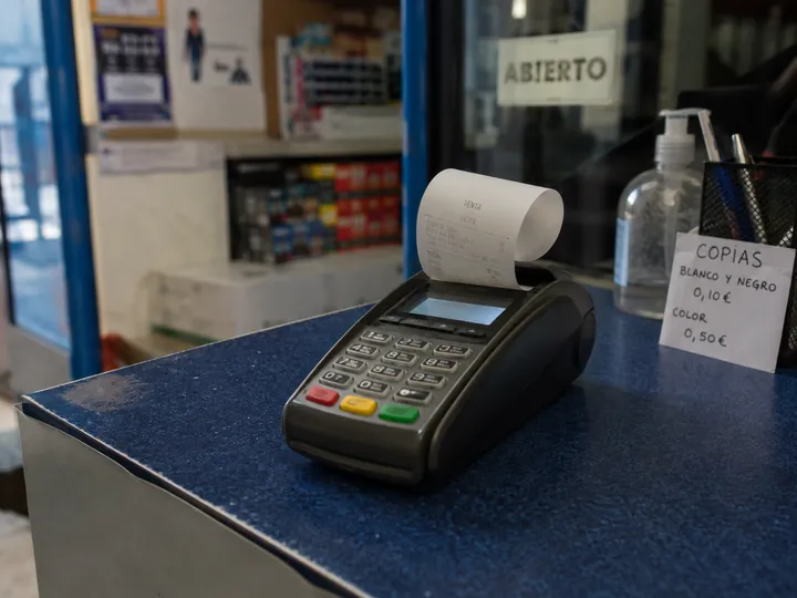 Datáfono con un recibo de pago en un mostrador