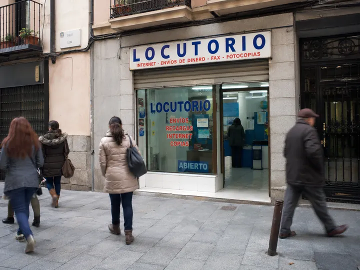Locutorio con la persiana metálica medio subida por la mañana